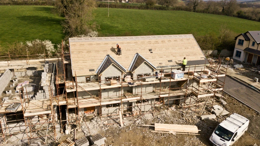 a truck parked in front of a house under construction, by Rachel Reckitt, unsplash, tiled roofs, aerial footage, limestone, promo image