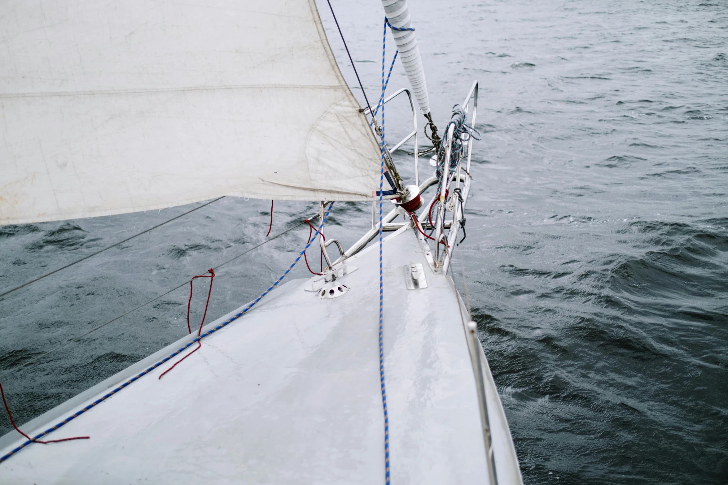 a close up of a sail boat on a body of water, unsplash, slight overcast weather, high - angle view, ignant, a cold