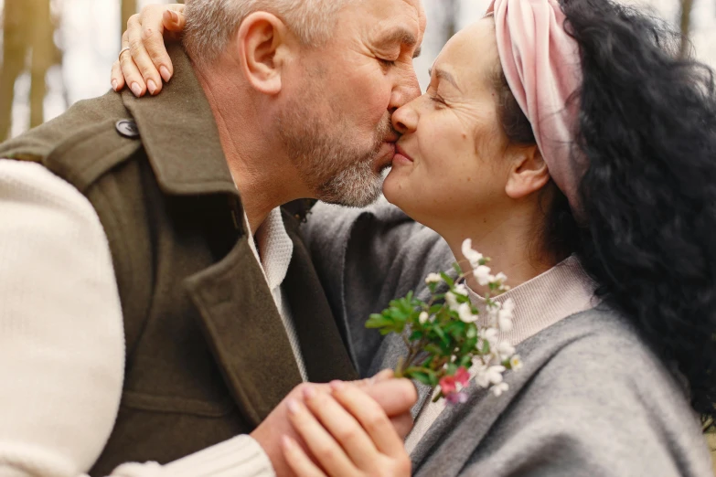 a man giving a woman a kiss on the cheek, inspired by Carl Larsson, unsplash, still from the film, elderly, holding flowers, serge marshennikov