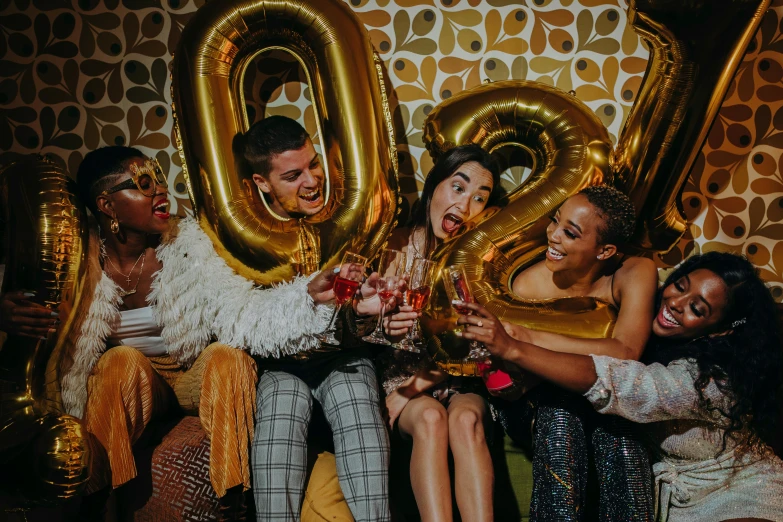 a group of people sitting next to each other at a party, trending on pexels, happening, golden number, man holding a balloon, promotional image, liquid gold