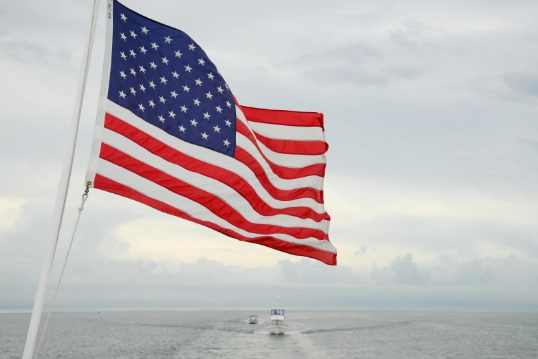 a large american flag flying over a body of water, a portrait, on a boat, profile image, ocean view, thumbnail