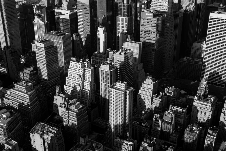 a black and white photo of a city, by Daniel Seghers, strong contrasting shadows, manhatten on top of skyscrapers, detailed 4 k photo, high - angle view