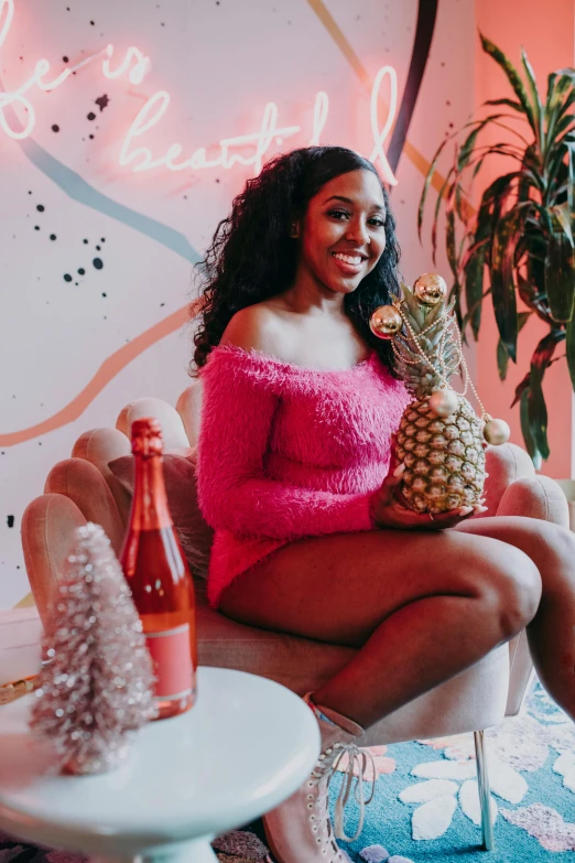 a woman sitting on a couch holding a pineapple, by Dulah Marie Evans, pexels contest winner, happening, hot pink, holiday, sza, holding a bottle