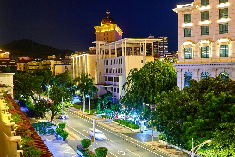 a city street at night with a clock tower in the background, pexels contest winner, shenzhen, tropical coastal city, square, tone mapped