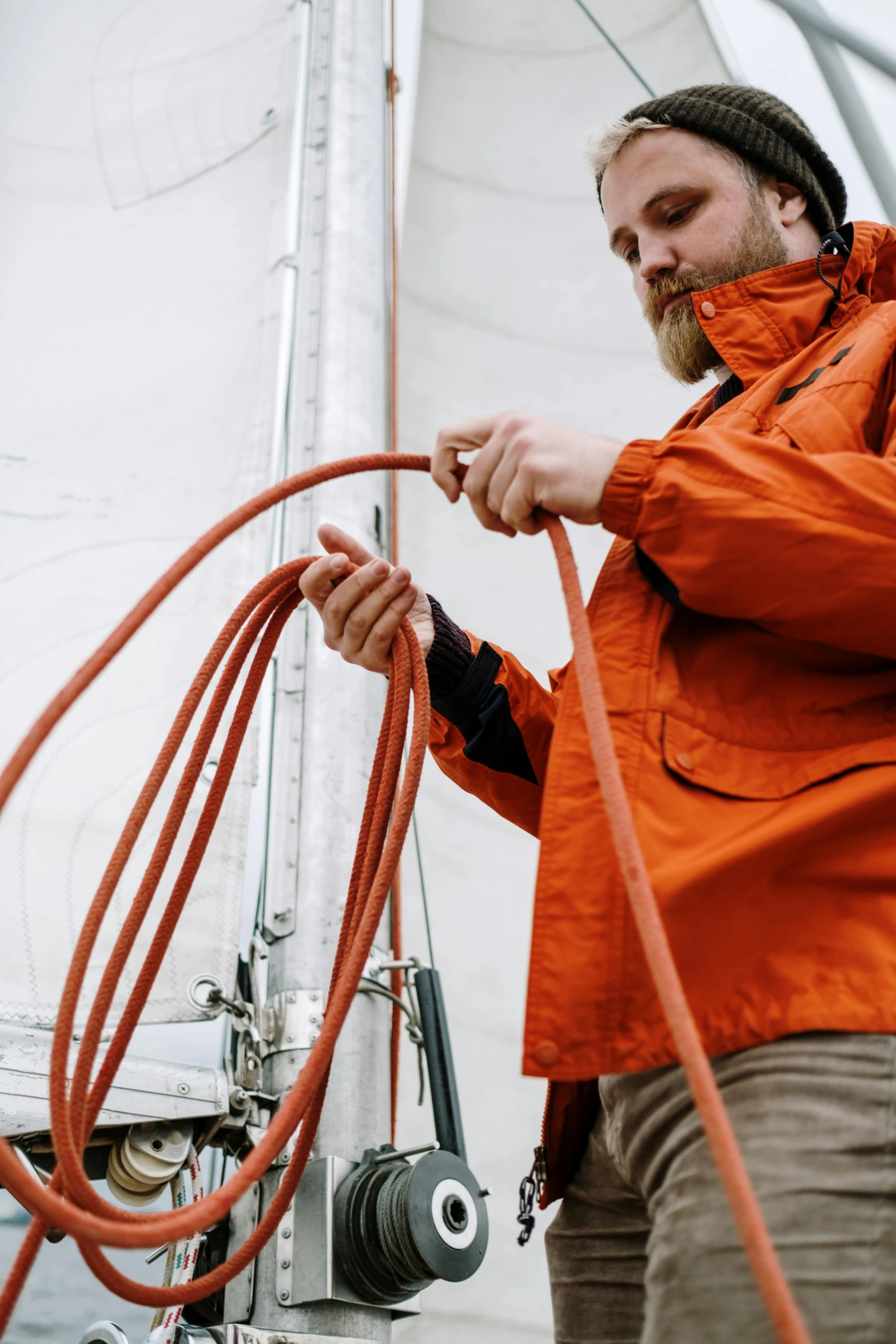 a man in an orange jacket holding a hose, sailpunk, connecting lines, up close, adventuring