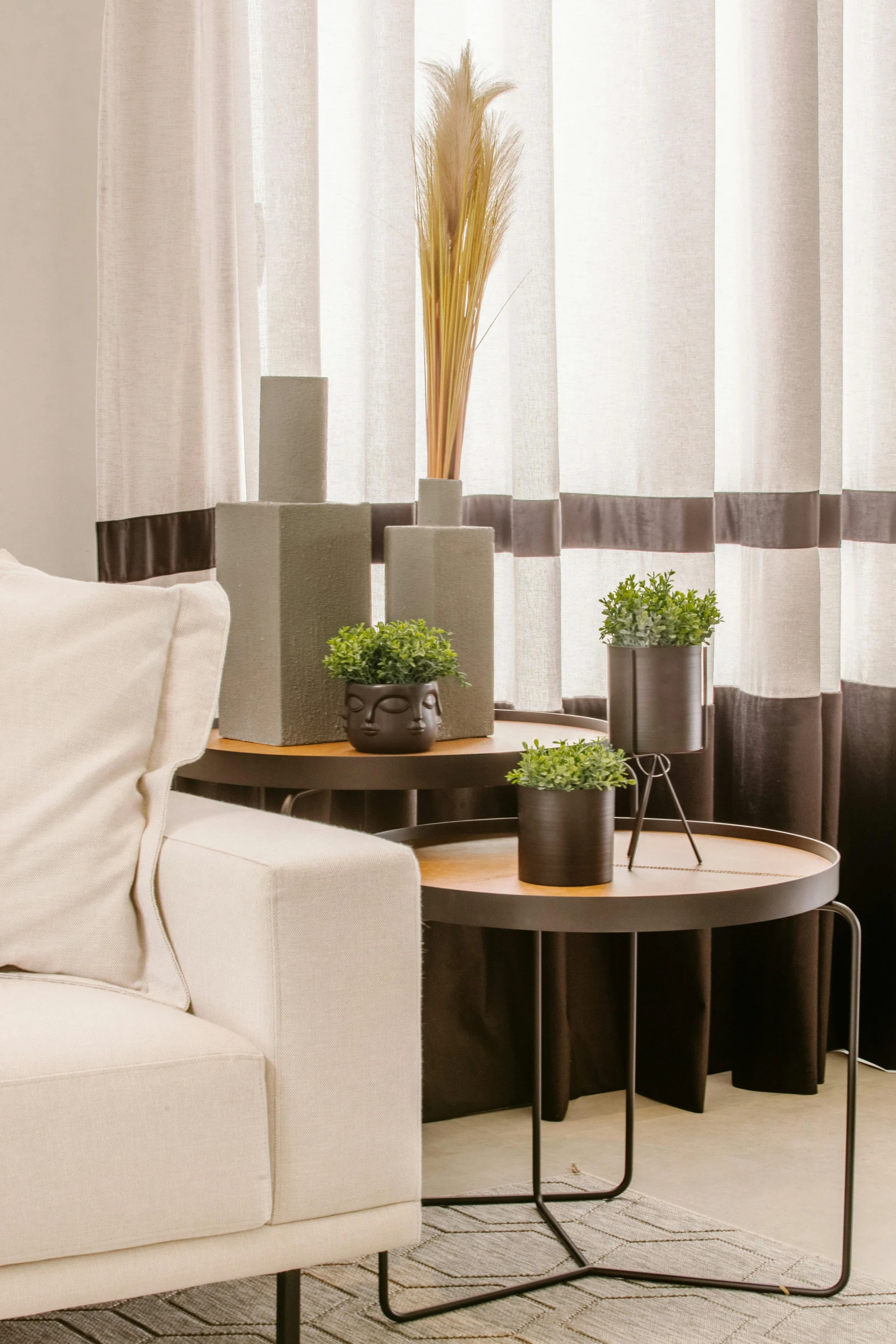 a white couch sitting in a living room next to a window, ikebana white flowers, wooden tables, dark brown white green colours, award - winning details