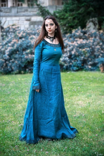 a woman in a blue dress standing in the grass, inspired by John William Waterhouse, pixabay contest winner, renaissance, clothed in ancient street wear, square, long dress female, dark teal