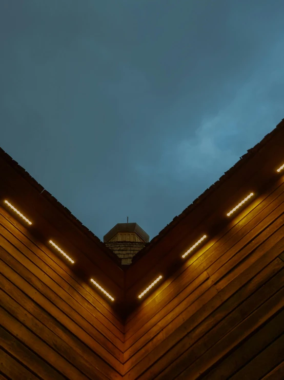 a clock that is on the side of a building, an album cover, by Attila Meszlenyi, unsplash contest winner, light and space, wooden ceiling, oled lights in corners, overcast, cabin lights