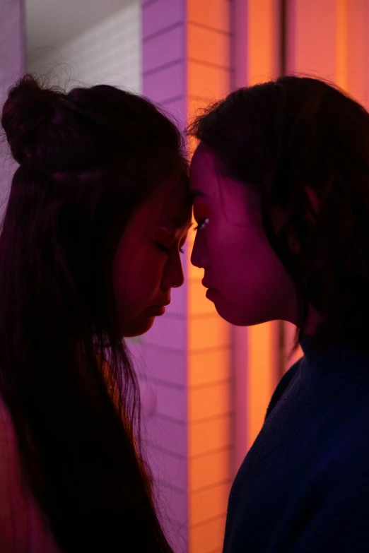 a couple of women standing next to each other, inspired by Nan Goldin, trending on pexels, realism, 8 0 s asian neon movie still, purple scene lighting, facing each other, a colorful