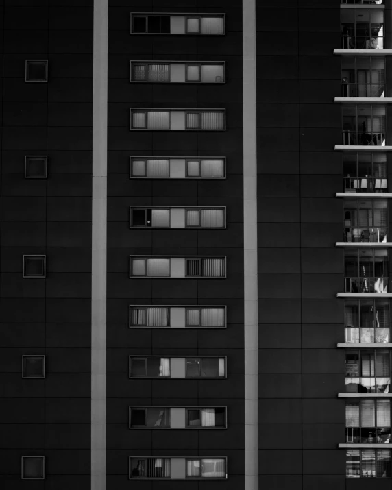 a black and white photo of a tall building, a black and white photo, inspired by Andreas Gursky, unsplash contest winner, balcony scene, dark colour scheme, ten flats, square