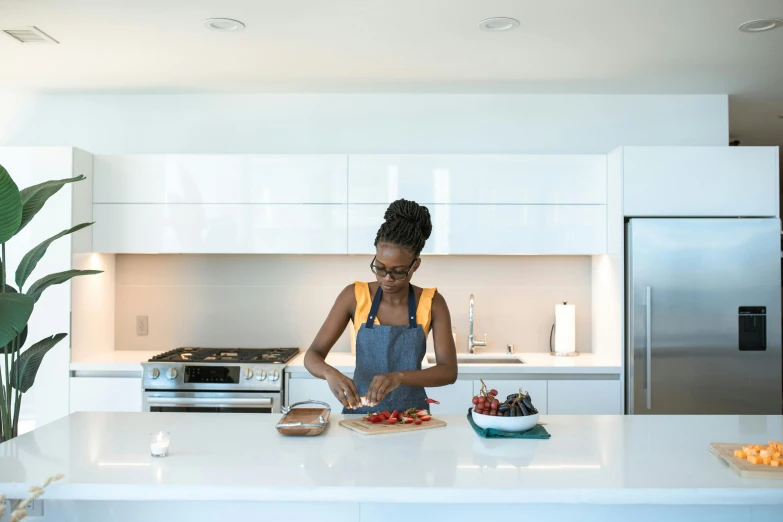 a woman standing in a kitchen preparing food, inspired by Richmond Barthé, pexels contest winner, nerdy black girl super hero, dwell, carving, architectural digest photo