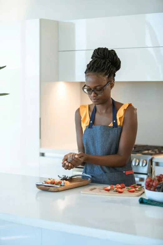 a woman standing in a kitchen preparing food, inspired by Edwin Georgi, pexels contest winner, nerdy black girl super hero, “berries, plating, manuka