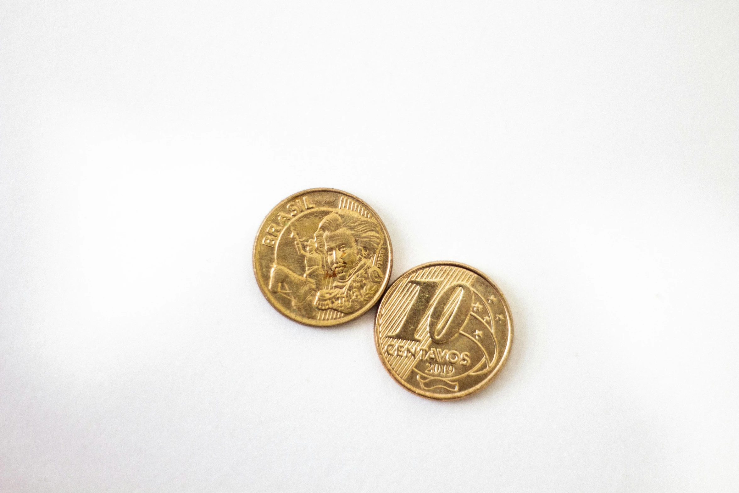 two coins sitting next to each other on a white surface, by Daniel Lieske, unsplash, art nouveau, chilean, oz series, snacks, size 1 0