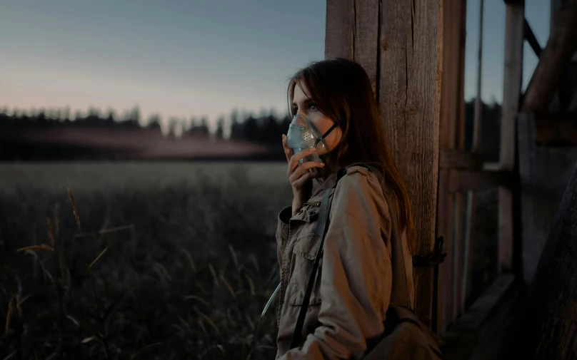 a woman wearing a face mask standing in a field, a picture, inspired by Elsa Bleda, pexels contest winner, graffiti, girl under lantern, stood outside a wooden cabin, oxygen mask, dusk atmosphere