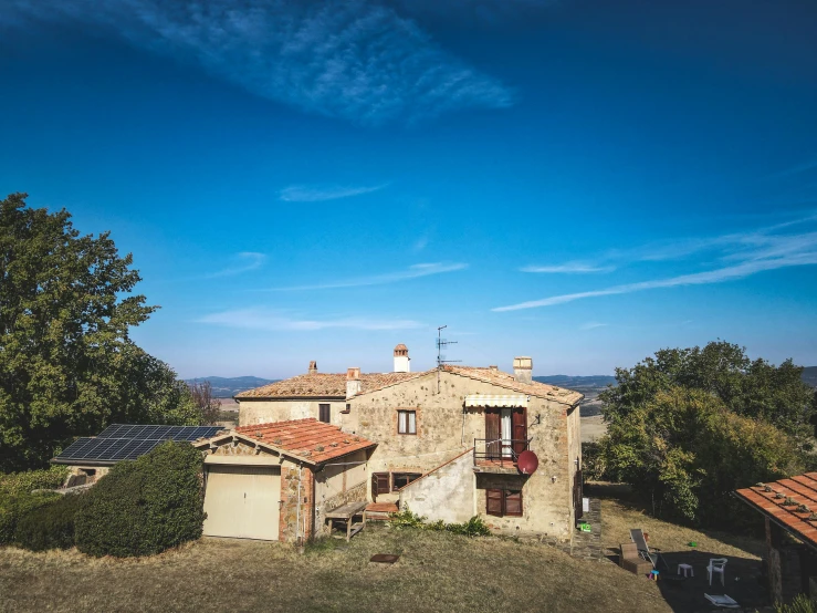 a house with solar panels on the roof, a portrait, by Francesco Furini, pexels contest winner, renaissance, wide view of a farm, rustic stone cabin in horizon, wide high angle view, afternoon light