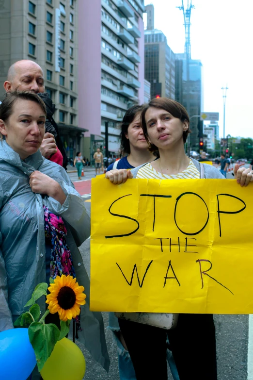 a group of people holding a sign that says stop the war, by Miroslava Sviridova, reddit, square, slide show, colombia, gettyimages