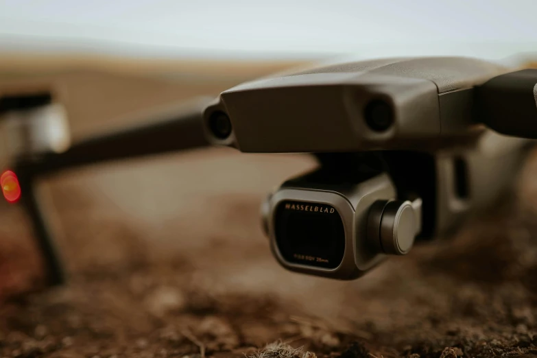 a close up of a camera attached to a drone, unsplash, taken with sony alpha 9, shot with hasselblade camera, ground angle, looking away from camera