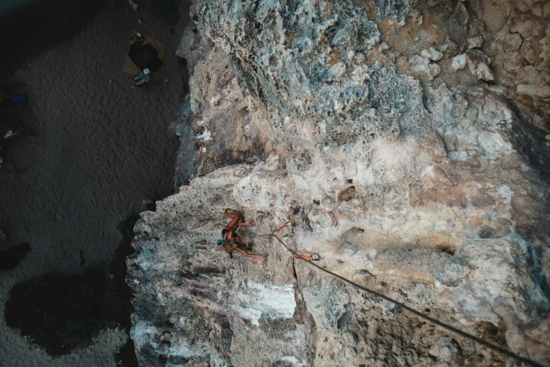 a man on a rock climbing up the side of a cliff, pexels contest winner, hurufiyya, aerial view cinestill 800t 18mm, thumbnail, hanging from the ceiling, brown