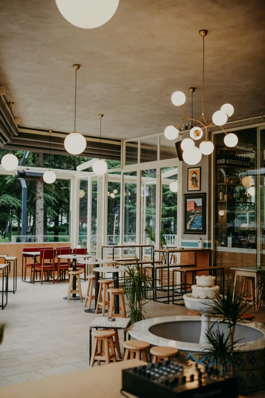 a room filled with lots of tables and chairs, unsplash, art nouveau, soft filtered outdoor lighting, glass room, bar, midcentury modern