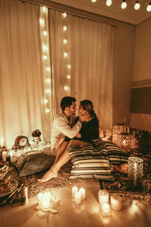 a man and woman sitting on a bed surrounded by candles, playful vibe, instagram picture, backdrop, february)