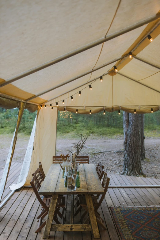 the inside of a tent with a table and chairs, kalevala, outside lighting, flat lay, deck