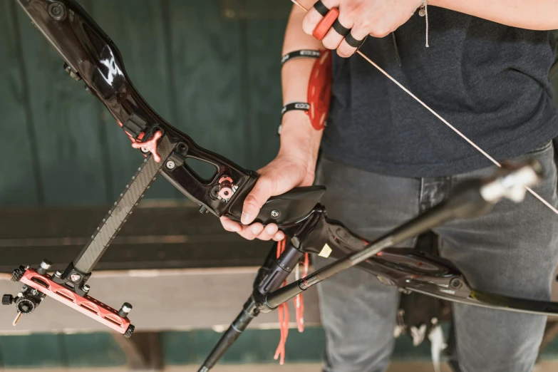a close up of a person holding a bow and arrow, mechanised, profile image, maintenance photo, straps