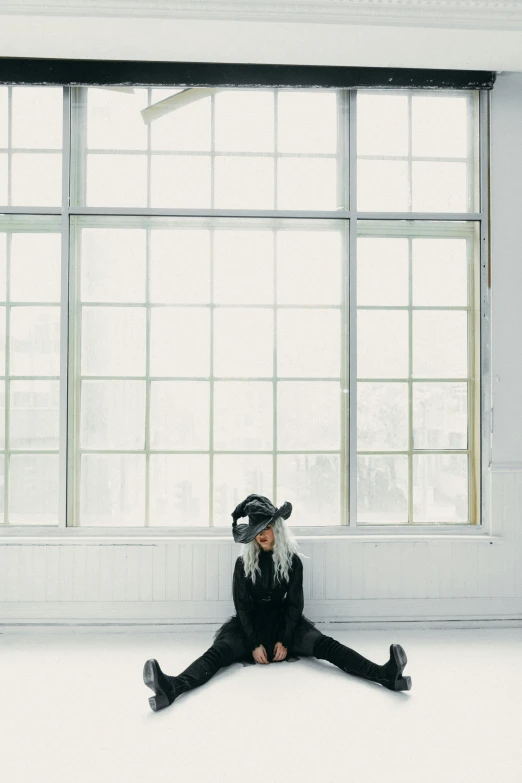 a woman sitting on the floor in front of a window, unsplash, hypermodernism, virtual reality headset, with long white hair, black hat, mid air