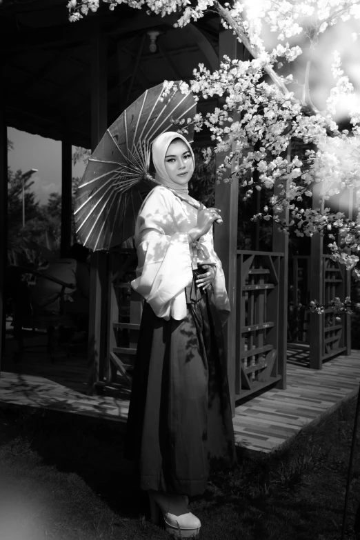 a black and white photo of a woman holding an umbrella, a black and white photo, inspired by Tang Di, tai costume, ✨🕌🌙, in style 19 century, queen of flowers