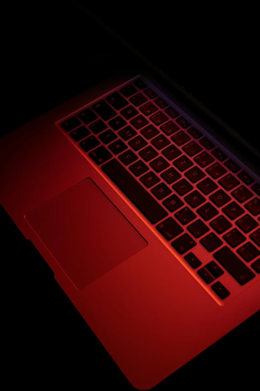 a red laptop computer sitting on top of a table, by Paul Bird, pexels, computer art, black light, metallic red, contain, blood red