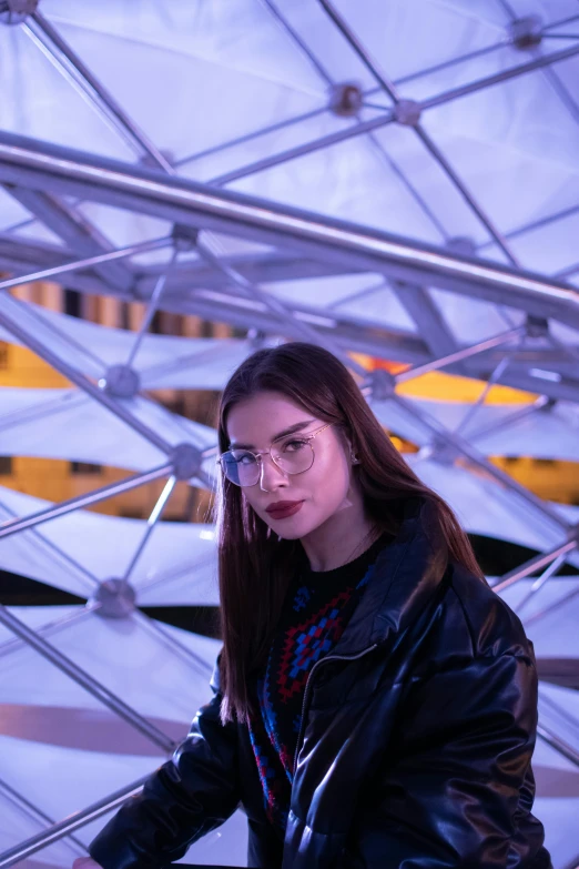 a woman in a black leather jacket and glasses, inspired by Elsa Bleda, pexels contest winner, visual art, at future neon light rooftop, hailee steinfeld, inside a dome, low quality photo