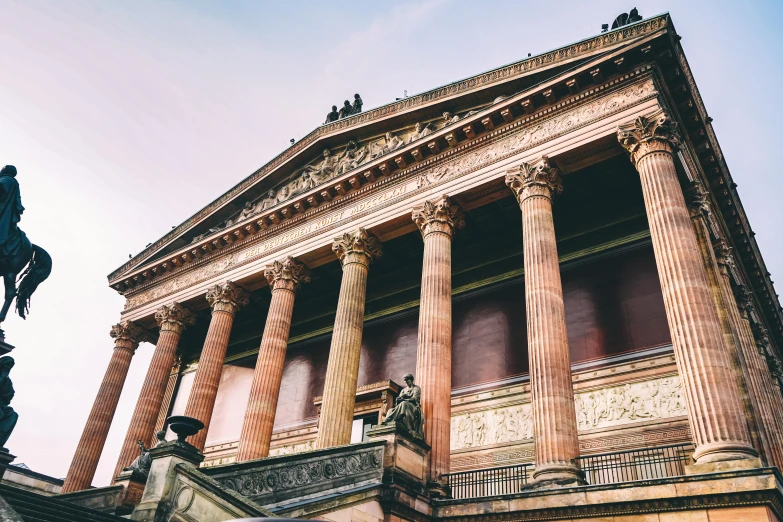 a statue of a man riding a horse in front of a building, inspired by Hubert Robert, pexels contest winner, neoclassicism, glasgow, wide grand staircase, in the style wes anderson, huge greek columns
