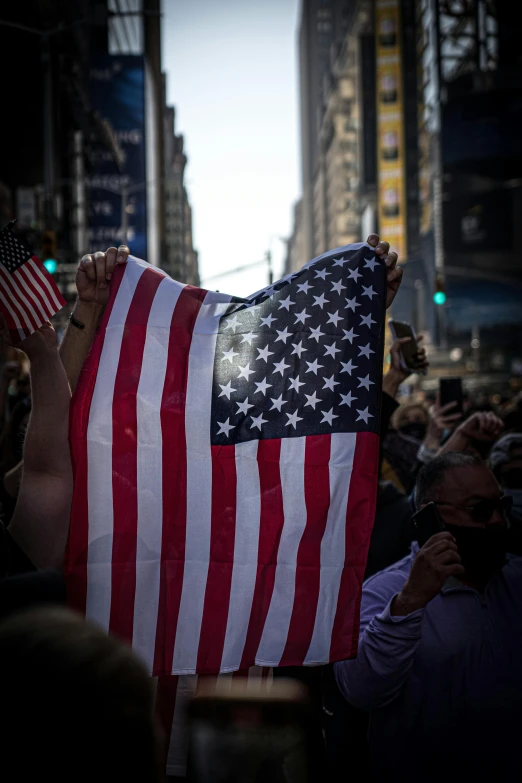 a person holding an american flag in the middle of a crowd, slide show, album, rectangle, image