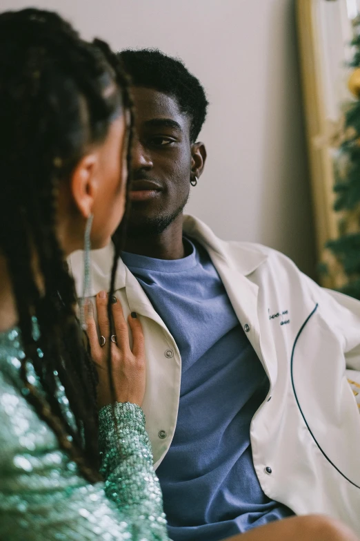 a man and woman sitting on a couch in front of a christmas tree, by Cosmo Alexander, trending on pexels, aestheticism, wearing a labcoat, man is with black skin, intimate holding close, playboi carti portrait