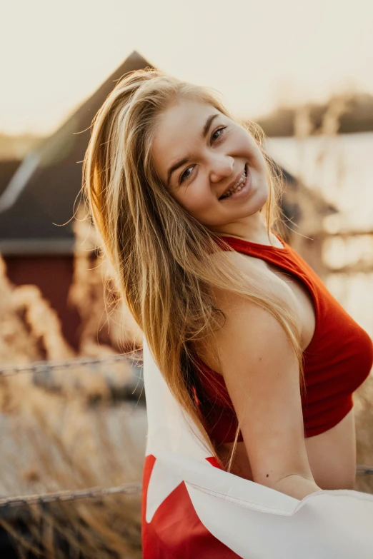 a woman in a red dress standing next to a fence, by Anna Haifisch, pexels contest winner, smiling young woman, cute girl wearing tank suit, blonde swedish woman, headshot profile picture