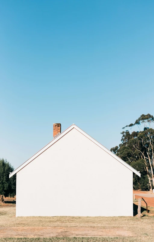 a white house sitting in the middle of a field, unsplash, postminimalism, melbourne, chimney, profile image, tiny house