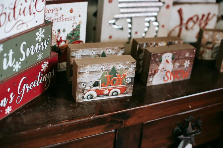 a couple of boxes sitting on top of a wooden table, a picture, pexels, folk art, santa's workshop, bright signage, profile image, three quarter view