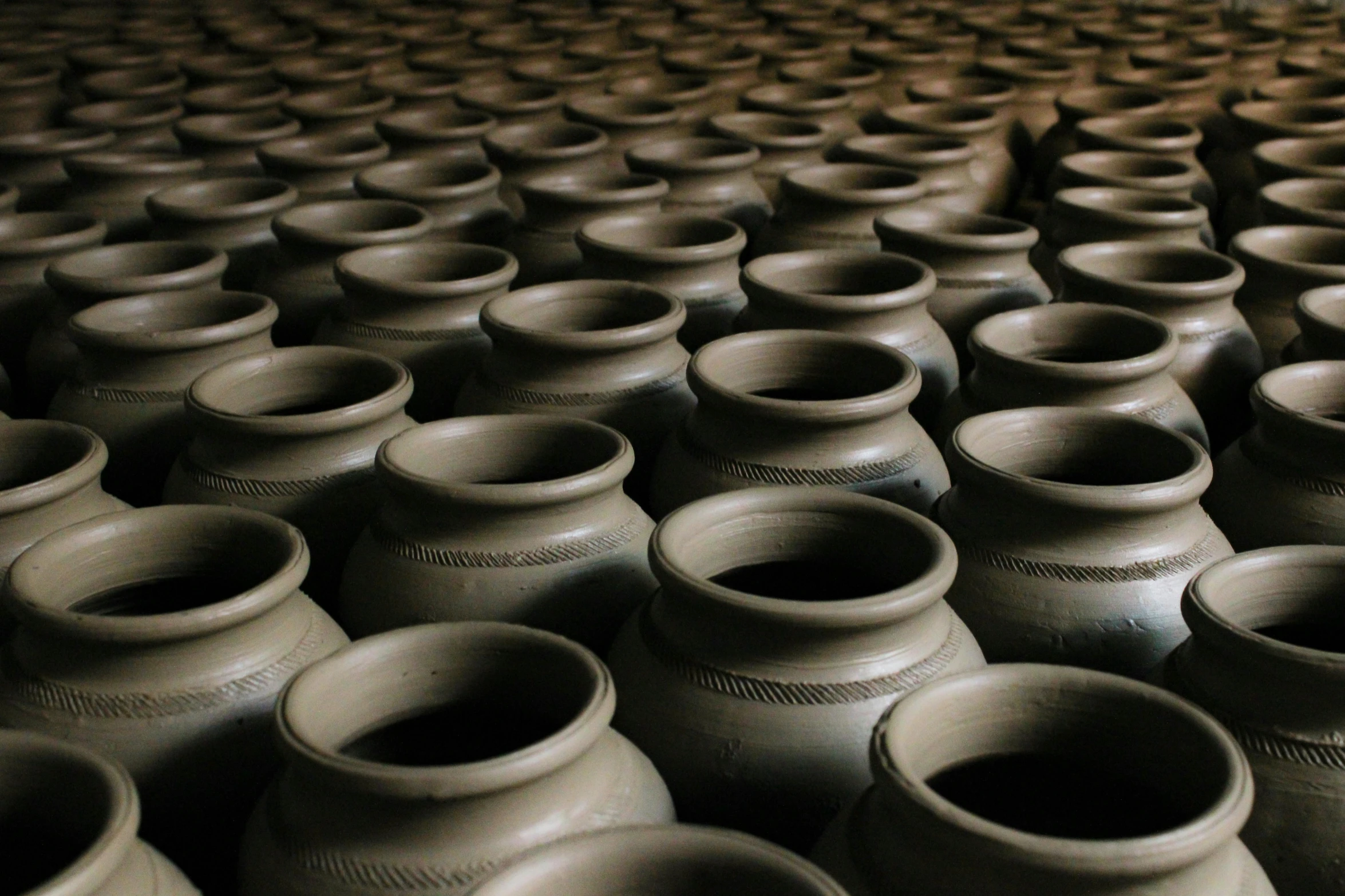 a bunch of clay pots sitting on top of a floor, inspired by Ai Weiwei, trending on unsplash, mingei, cellar, background: assam tea garden, traditional korean city, thumbnail