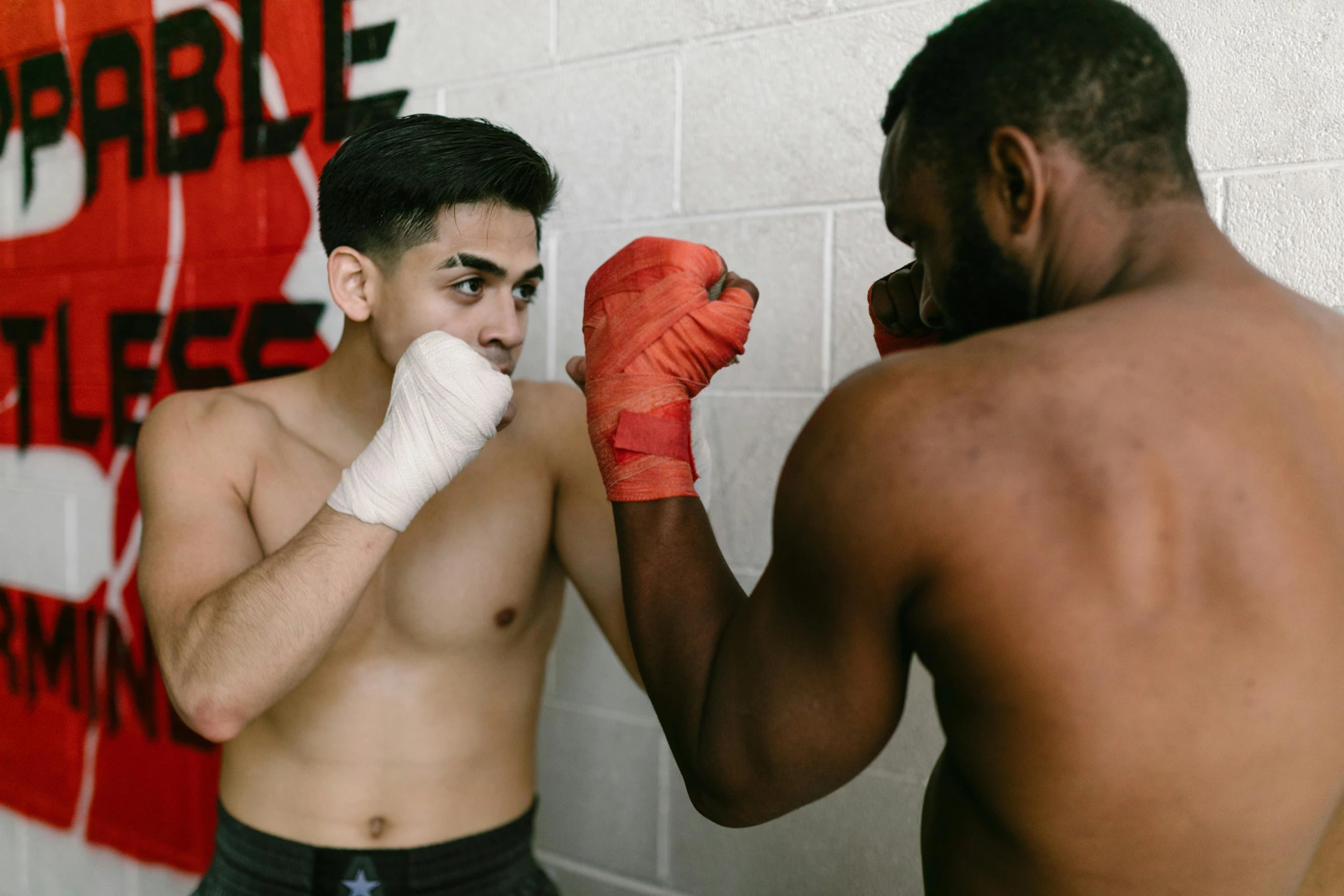 a couple of men standing next to each other, by Arabella Rankin, pexels contest winner, happening, sparring, marked muscles, varying ethnicities, person in foreground