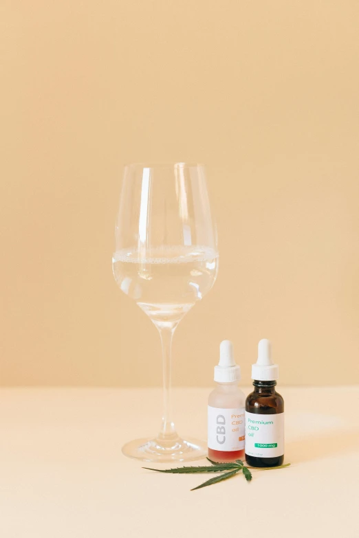 a bottle of cbd oil next to a glass of water, by Nicolette Macnamara, wine glass, focus on full - body, product view, 5