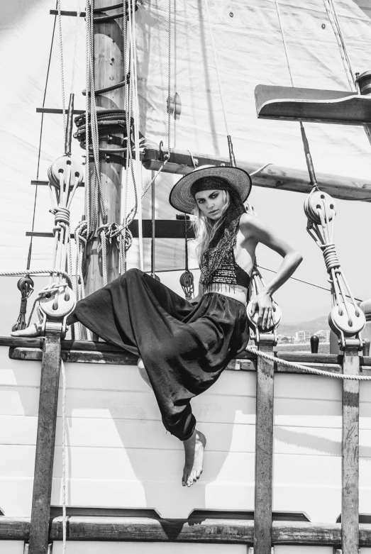 a black and white photo of a woman sitting on a boat, a black and white photo, inspired by Herb Ritts, renaissance, beautiful cowboy witch, on the deck of a sailing ship, steampunk clothes, trending on imagestation