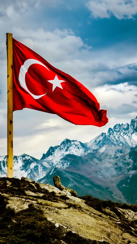 a flag on top of a mountain with mountains in the background, by Nevin Çokay, shutterstock contest winner, hurufiyya, turkey, square, slide show, conde nast traveler photo