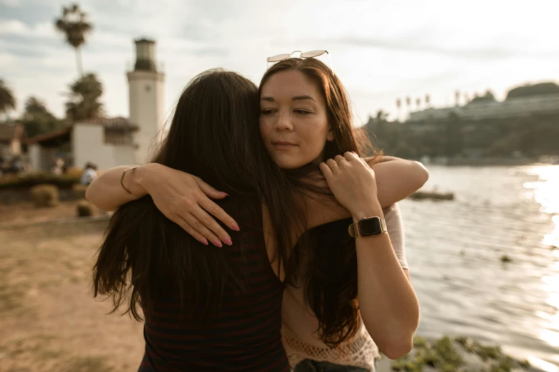 two women standing next to each other on a beach, pexels contest winner, happening, hugging, brunettes, pokimane, connectivity