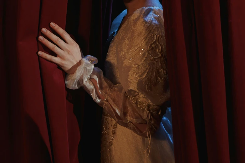 a woman standing in front of a red curtain, inspired by Georges de La Tour, unsplash, rococo, wearing gloves, wearing long silver robes, ( ( theatrical ) ), exterior shot