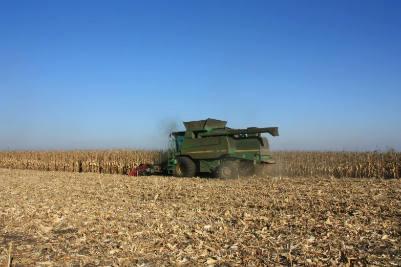 a combine harvester in the middle of a corn field, by Joe Stefanelli, slide show, journalism photo