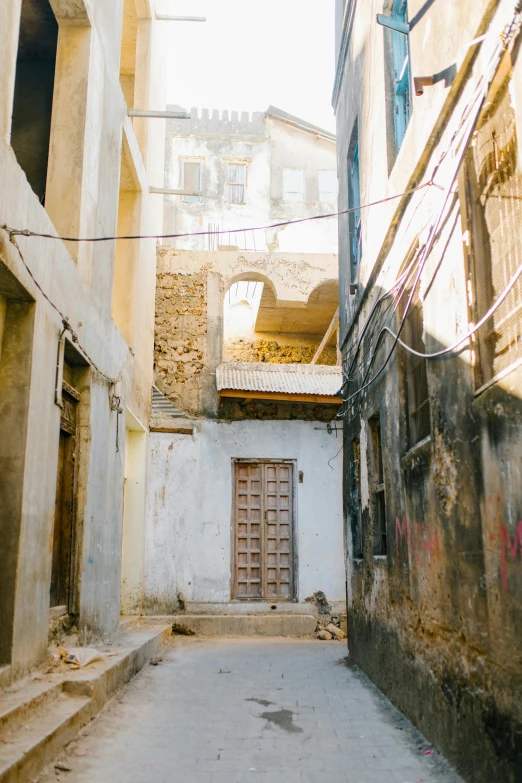 a narrow alley with a building in the background, somalia, fan favorite, deteriorated, half turned around
