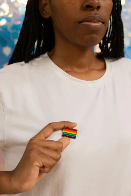 a close up of a person holding a small object, inspired by Okuda Gensō, trending on pexels, alexandria ocasio-cortez, badge, lesbians, 33mm photo
