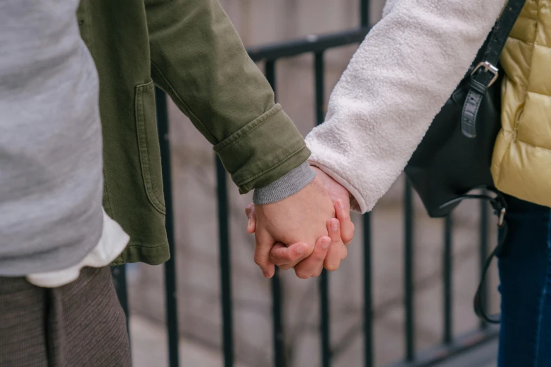 a close up of two people holding hands, a picture, trending on pexels, holding a stuff, 😭🤮 💔, in an urban setting, owen klatte