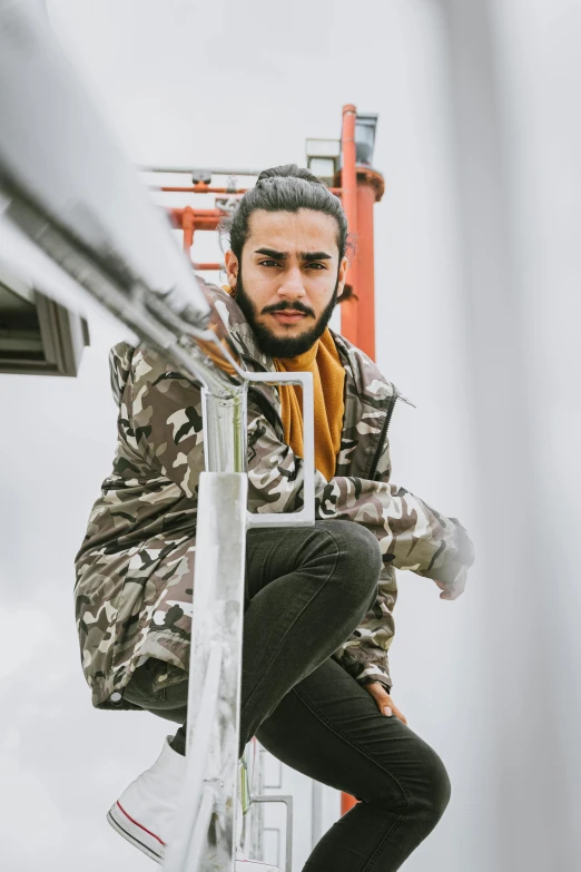 a man sitting on top of a ladder, trending on pexels, wearing hunter coat, arab man light beard, camo, urban clothing