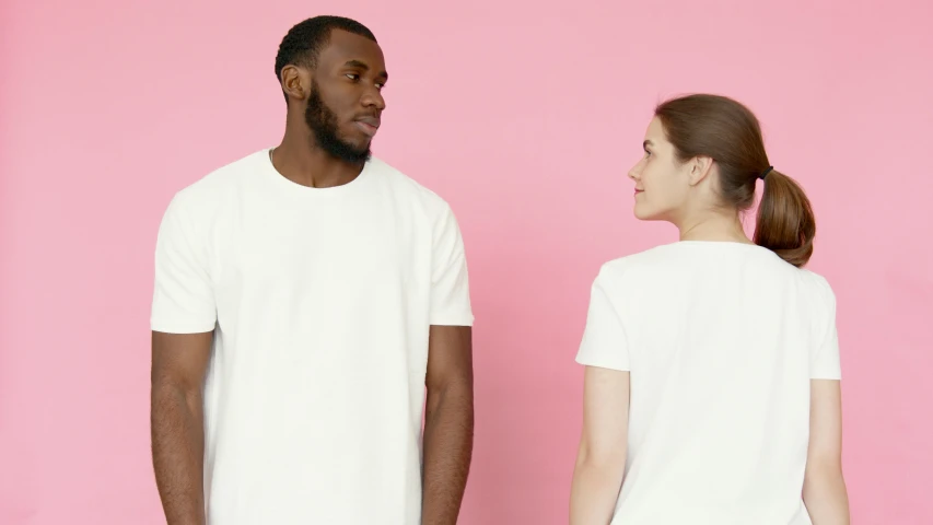 a man and a woman standing next to each other, trending on pexels, white and pink, plain white tshirt, dark people discussing, large tall