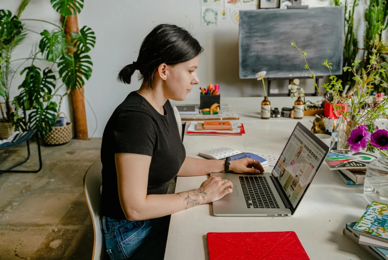 a woman sitting at a table using a laptop computer, pexels contest winner, ouchh and and innate studio, ariel perez, avatar image